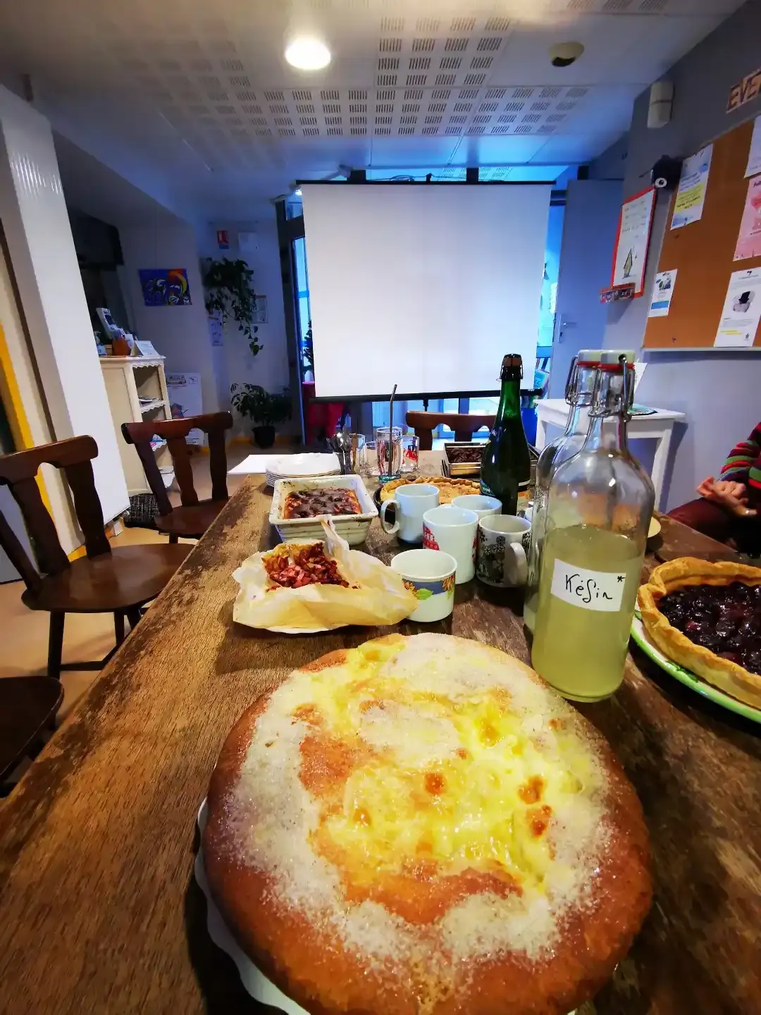 Une table couverte de gâteaux maison, de tartes et de bouteilles de kéfir